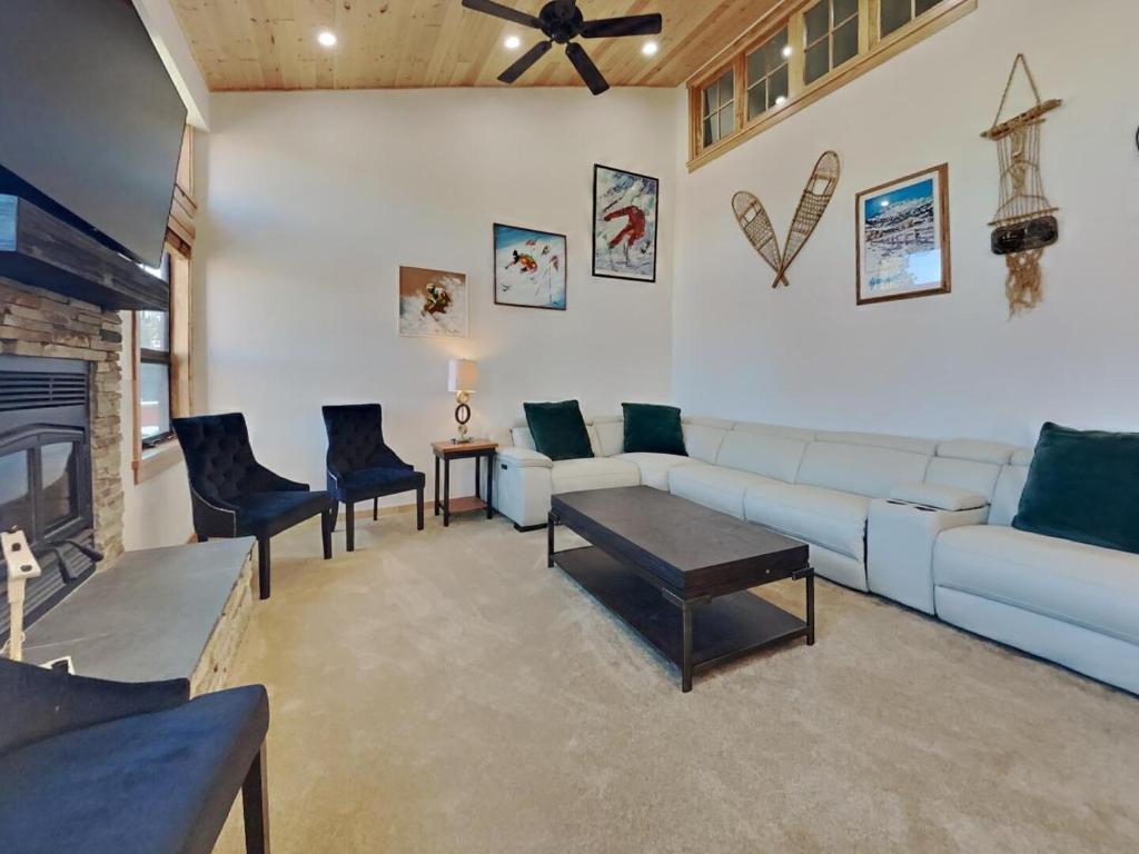 a living room with a white couch and chairs at Spacious 3 BR Condo with Loft in Mammoth Lakes