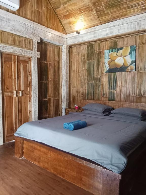 a bedroom with a large bed in a wooden room at Kushak bungalow Gili Trawangan in Gili Trawangan