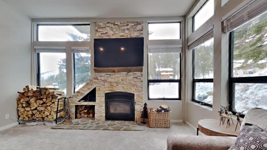 马姆莫斯湖1849 Condos 511 condo的客厅设有石制壁炉和电视