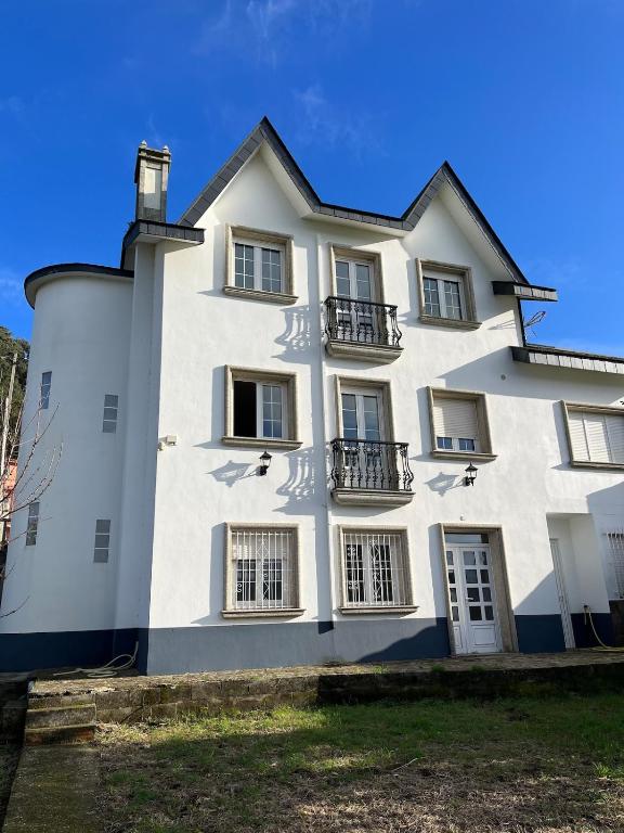 a large white building with windows on the side of it at Casa Flor de Lis in Cee