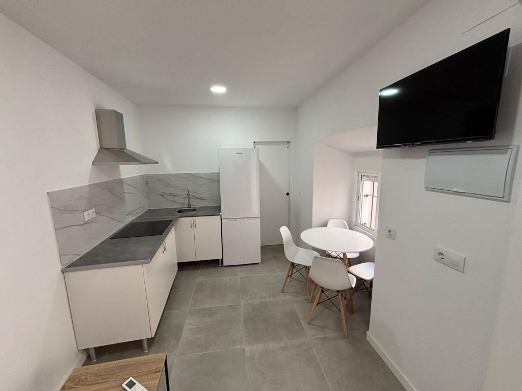 a kitchen with a table and a small table and chairs at Entresueños de Arcos in Arcos de la Frontera