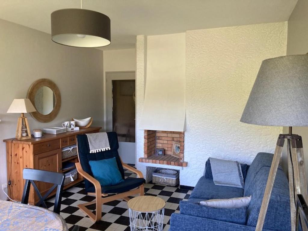 un salon avec un canapé bleu et une cheminée dans l'établissement Grand 2P, balcon sud, local vélo, Villard-de-Lans - FR-1-689-133, à Villard-de-Lans