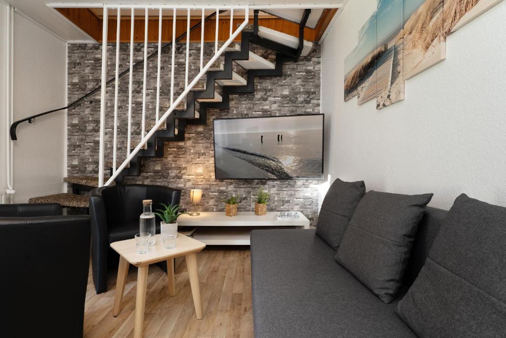 a living room with a couch and a staircase at Gästehaus Sulsdorf Wohnung 8 in Sulsdorf auf Fehmarn