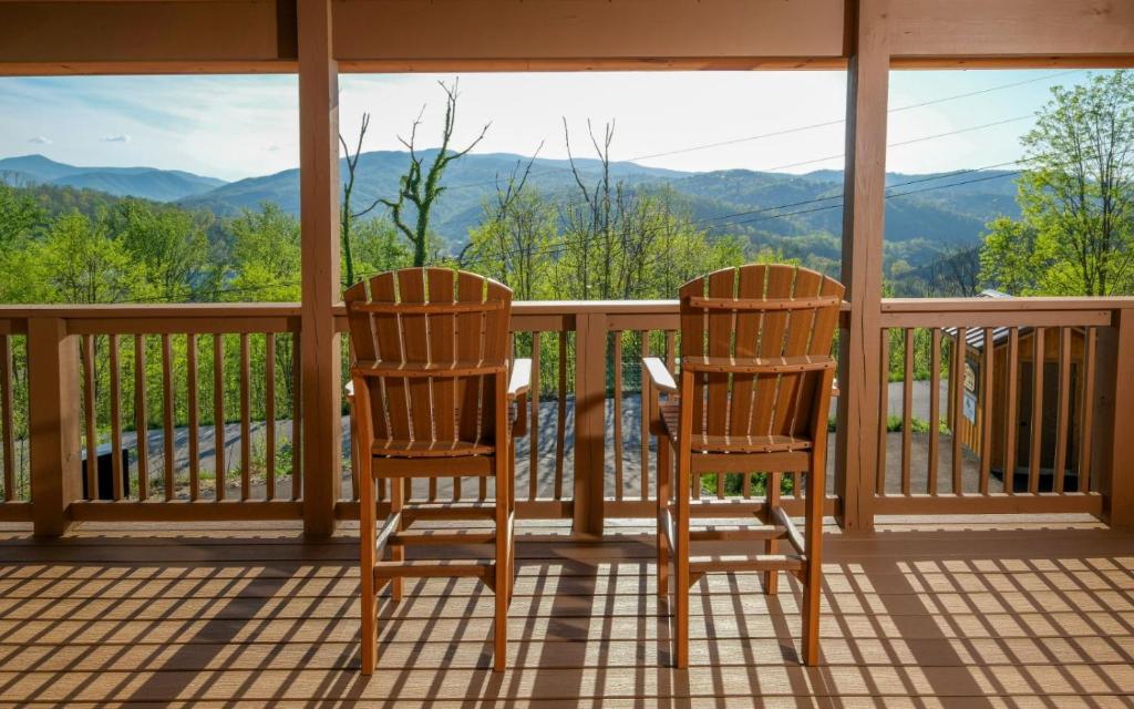 two chairs on a porch with a view of mountains at Hot tub and game room! - Black Bear Crossing in Gatlinburg