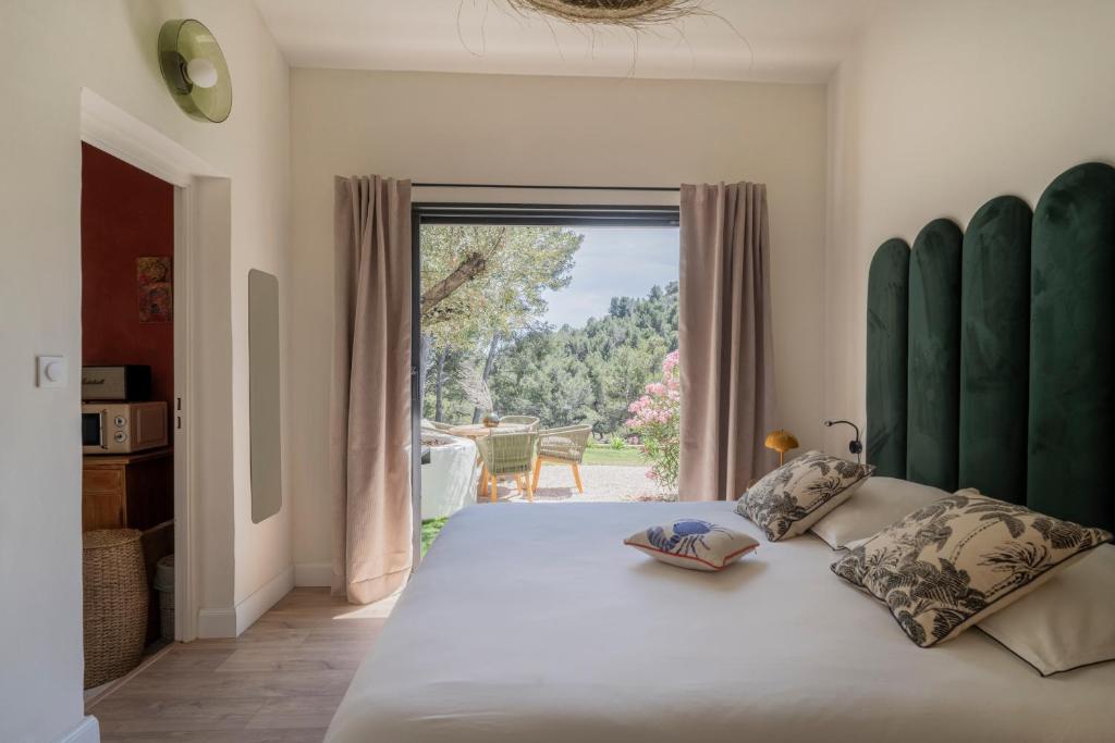 a bedroom with a large bed with a large window at L'hôtel des oiseaux in Les Baux-de-Provence