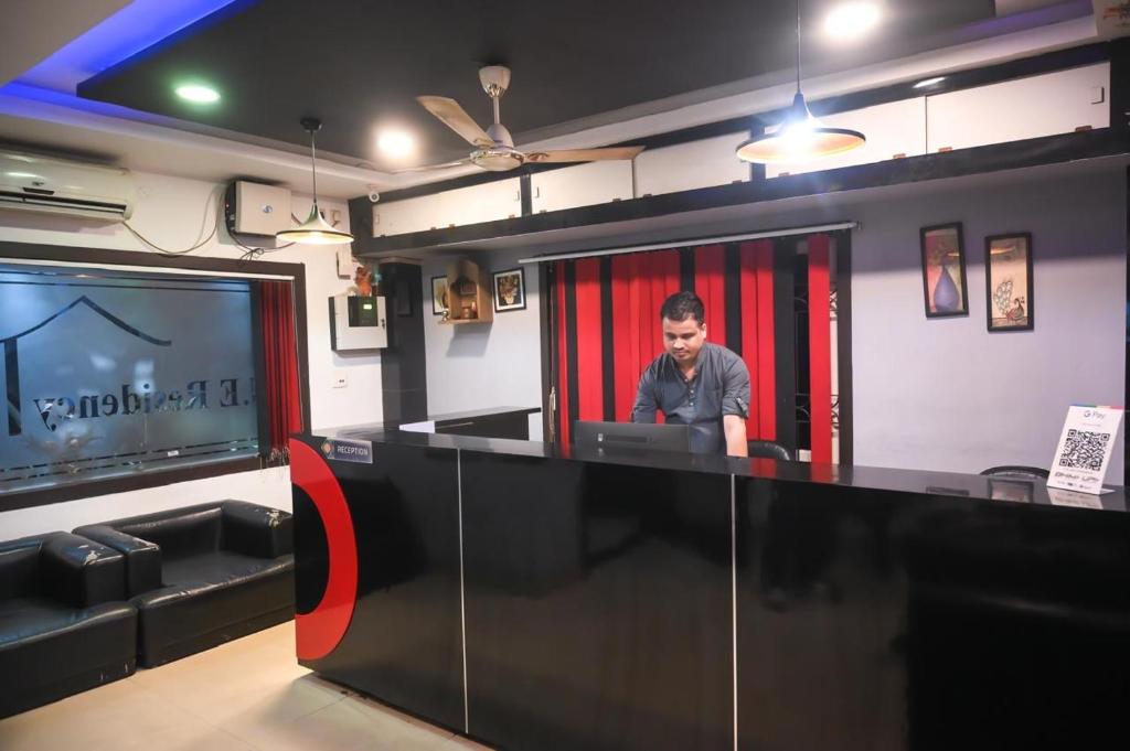 Un hombre sentado en un escritorio en una habitación con un televisor. en Rudra Group, en Guwahati