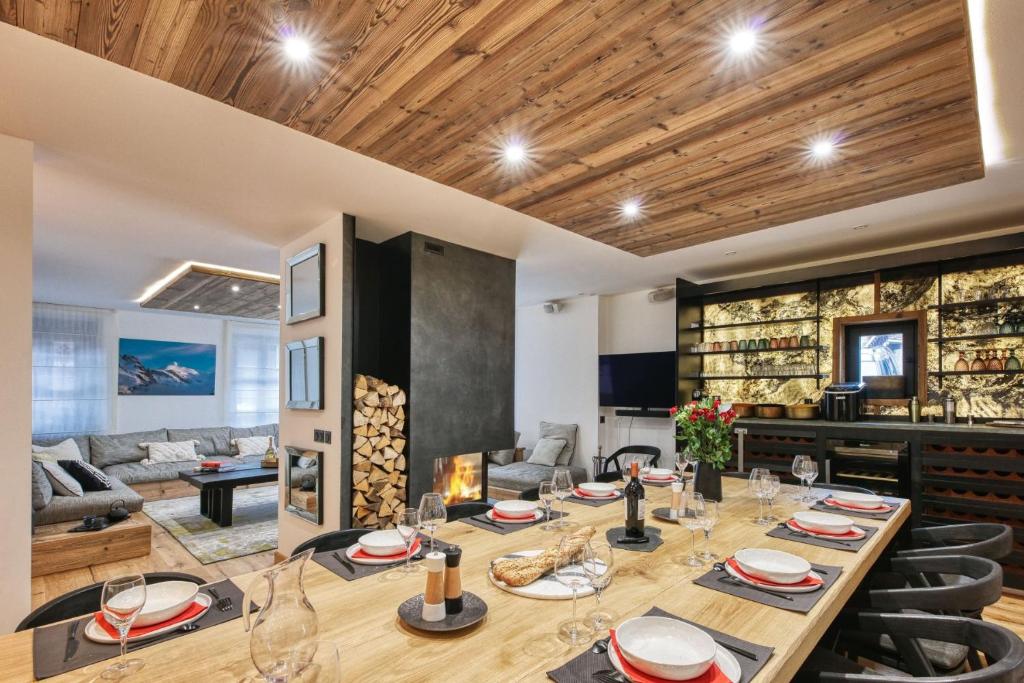 une salle à manger avec une longue table et des chaises dans l'établissement Le Marti, à Chamonix-Mont-Blanc