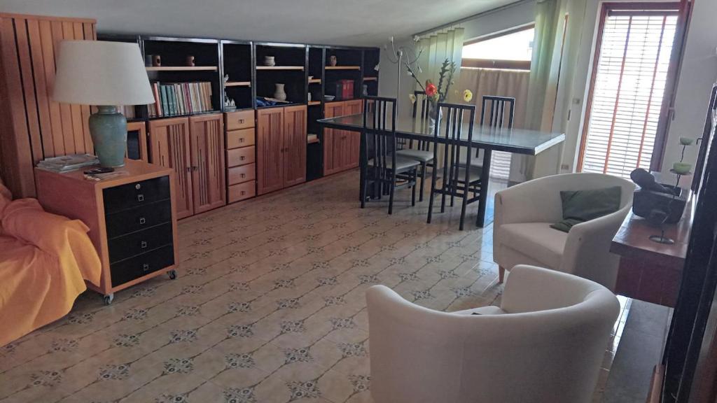 a living room with a dining table and a dining room at Appartamento Napodano in Tortora