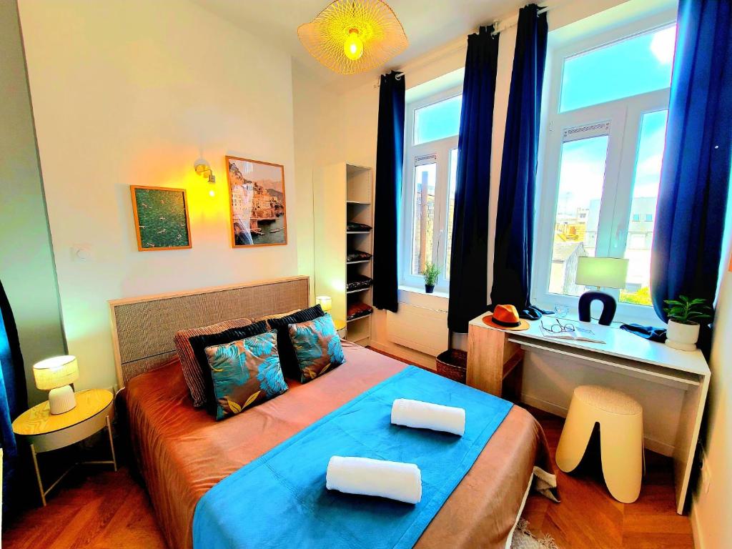 une chambre avec un lit et un bureau dans l'établissement LA BRISE Maison de charme en hyper centre prés du port et des plages, à Boulogne-sur-Mer