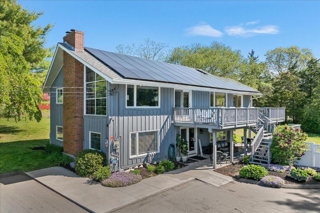 a house with a porch and a balcony at Unique Retreat with Private Patio, 4 King Beds and BBQ in Groton
