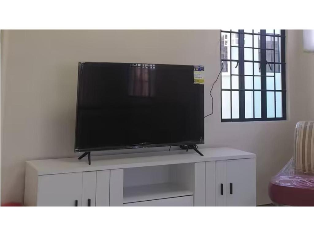 a flat screen tv sitting on top of a white cabinet at Peaceful Haven in Hermosa, Philippines - Entire House for Rent in Hermosa