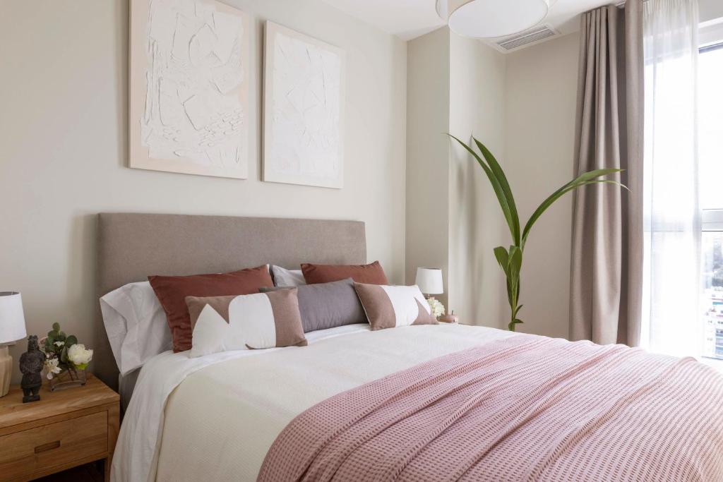 Hotel Urban Sky Malaga Antonio, a bedroom with a large bed with a pink blanket at Urban Sky Malaga Antonio in Málaga