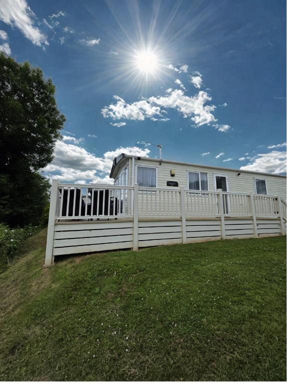 a white house behind a white picket fence at Edgewater Retreat- Pet Friendly-On Award winning Hoburne Devon bay in Goodrington