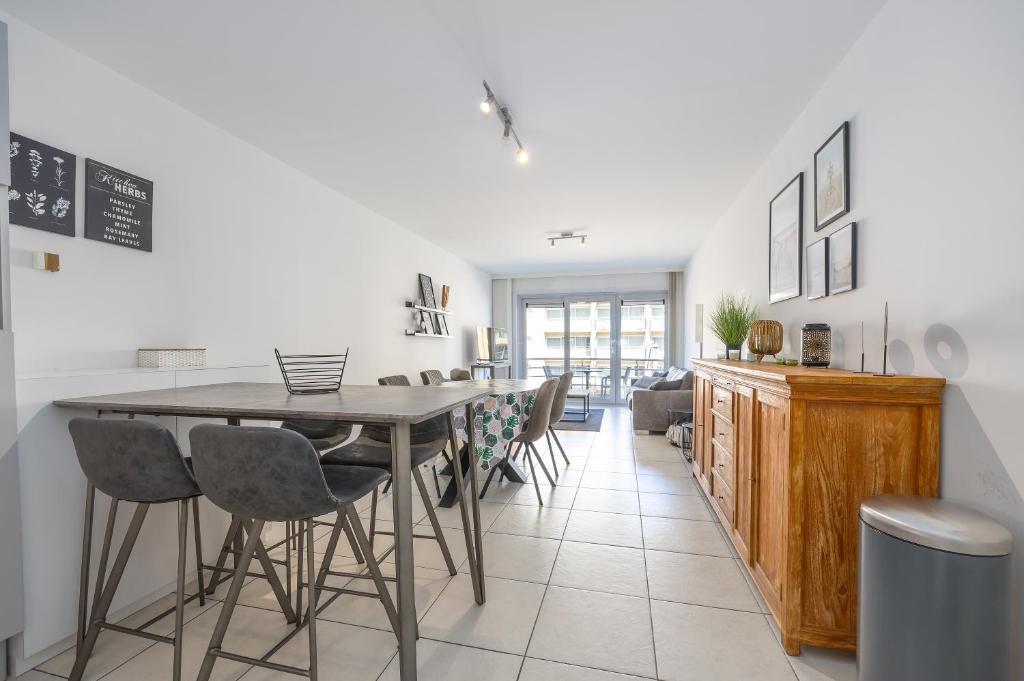 a kitchen and dining room with a table and chairs at Volledig gerenoveerd 2 slaapkamer appartement in Westende-Bad, 250 m van het strand in Westende Bad