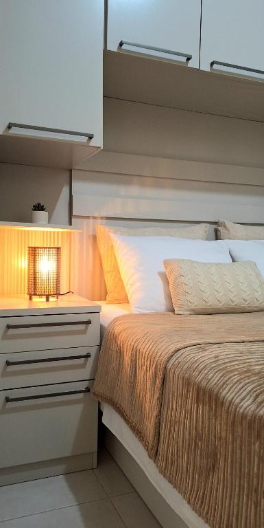 a bedroom with a bed with a light on it at Casa próxima ao Parque das Águas in São Lourenço