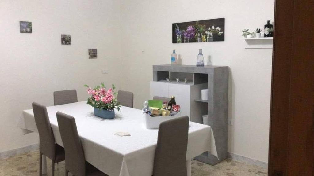 a white table with chairs and flowers on it at Casa vacanza dai Nonni Ntoni in Acquarica del Capo