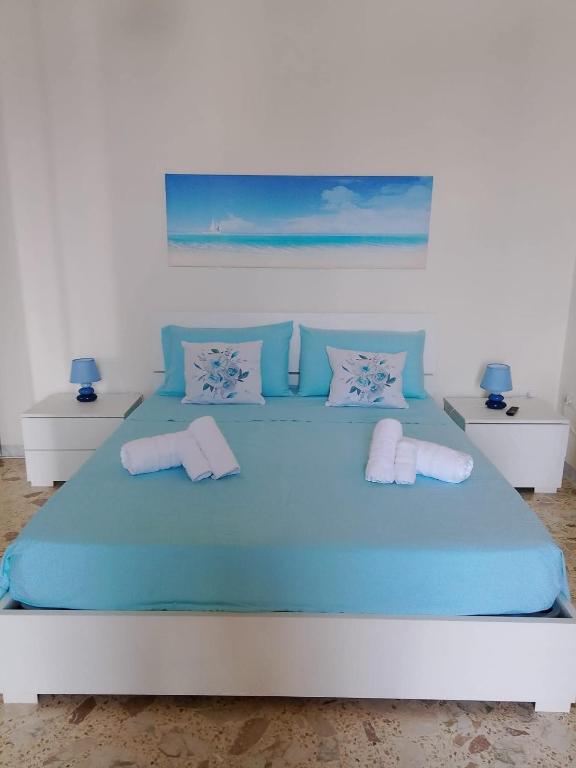 a bedroom with a blue bed with two pillows at Casa vacanza dai Nonni Ntoni in Acquarica del Capo