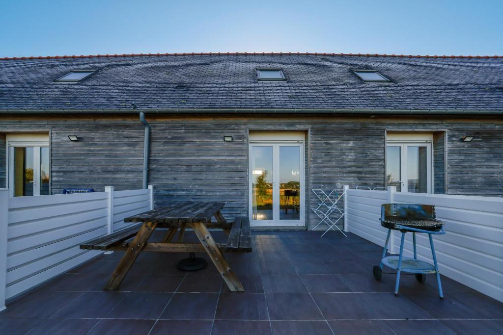 une terrasse avec une table en bois et deux tabourets dans l'établissement Gite Gwenn ha du, à Cast