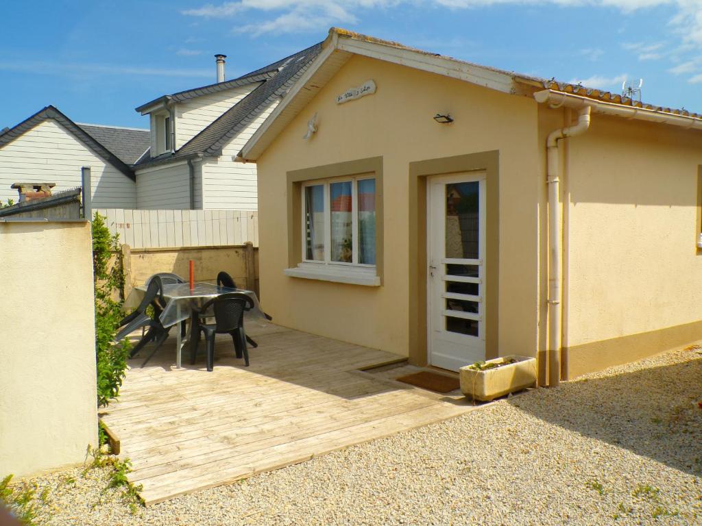 a patio with a table and a house at La Villa d'Elisa in Saint-Côme-de-Fresné