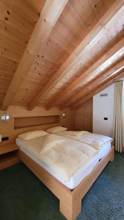 Postel nebo postele na pokoji v ubytování Alpenroyal Arabba