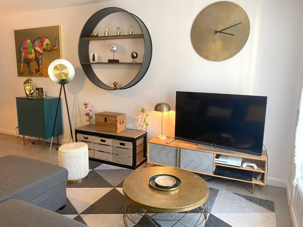 un salon avec une télévision à écran plat et une table dans l'établissement Appartement 3* rénové, 1 chambre, WIFI, à 200m plage de Trégastel, centre, vélos électriques offerts - FR-1-368-229, à Trégastel