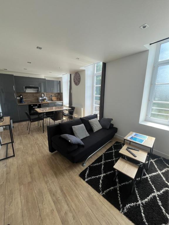 un salon avec un canapé noir et une table dans l'établissement L'Escapade Côte d'Opale, à Boulogne-sur-Mer