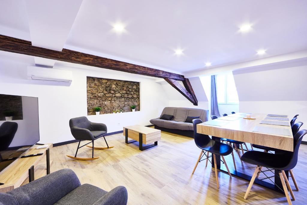 a living room with a wooden table and chairs at TH 202 Charmant duplex F4 au 2ème étage - 7 personnes in Thann