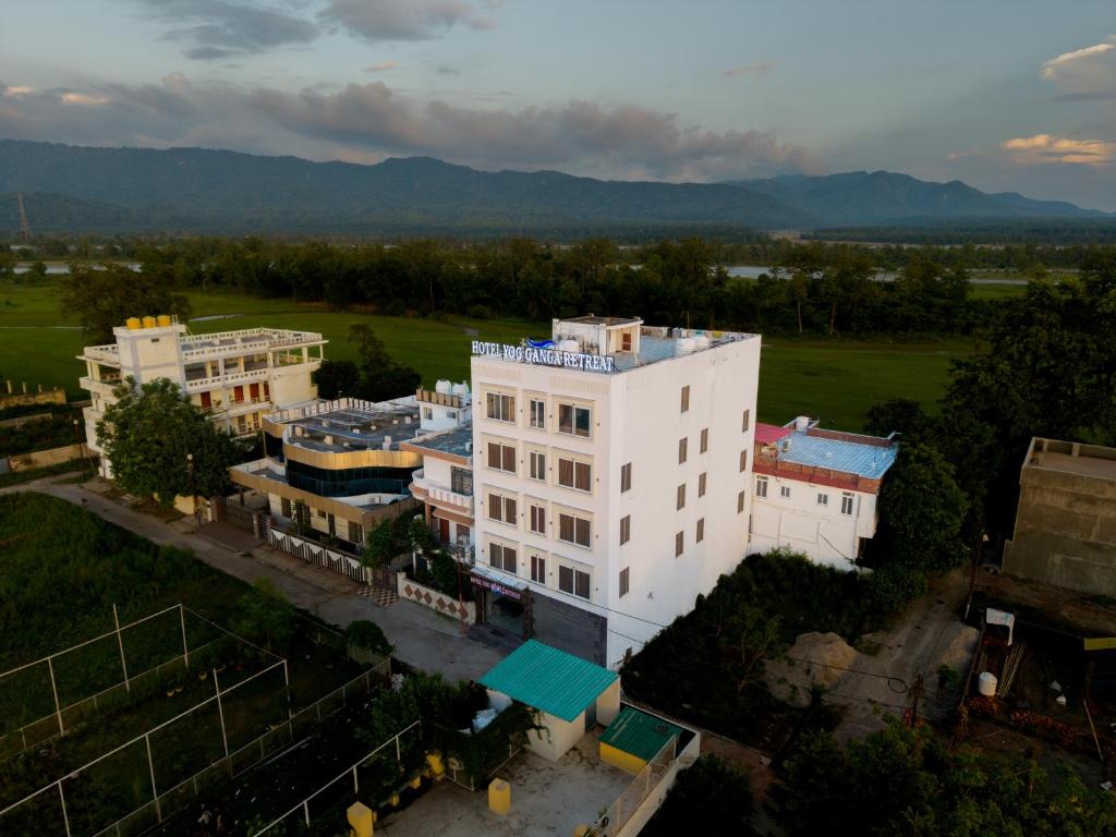 an aerial view of a white building with mountains in the background at Hotel Yog Ganga Retreat in Rishīkesh