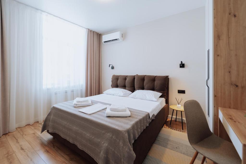 ein Schlafzimmer mit einem großen Bett mit Handtüchern darauf in der Unterkunft Business-Ready NEW 1BR - Main Street Living in Chişinău