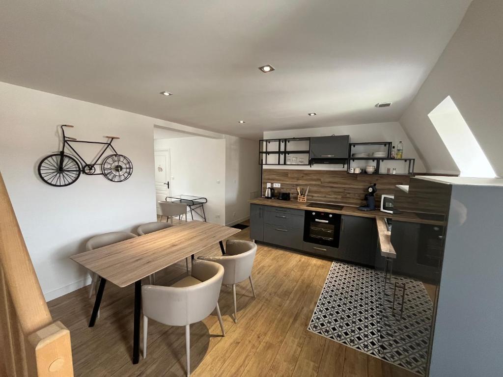 a kitchen and dining room with a table and a bike on the wall at La Perle de la Côte in Boulogne-sur-Mer