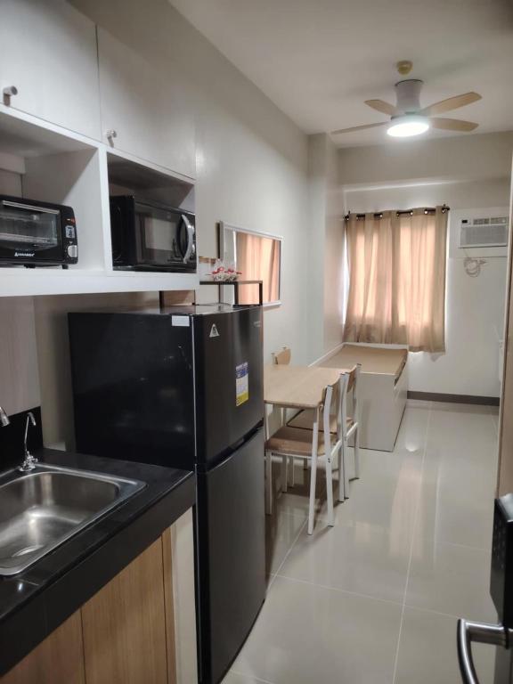 a small kitchen with a sink and a table at 2BR Condo SMDC Charm Metro Manila in Manila