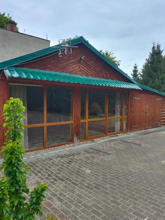 a building with large windows and a green roof at Sosnowa Polana in Lipinki