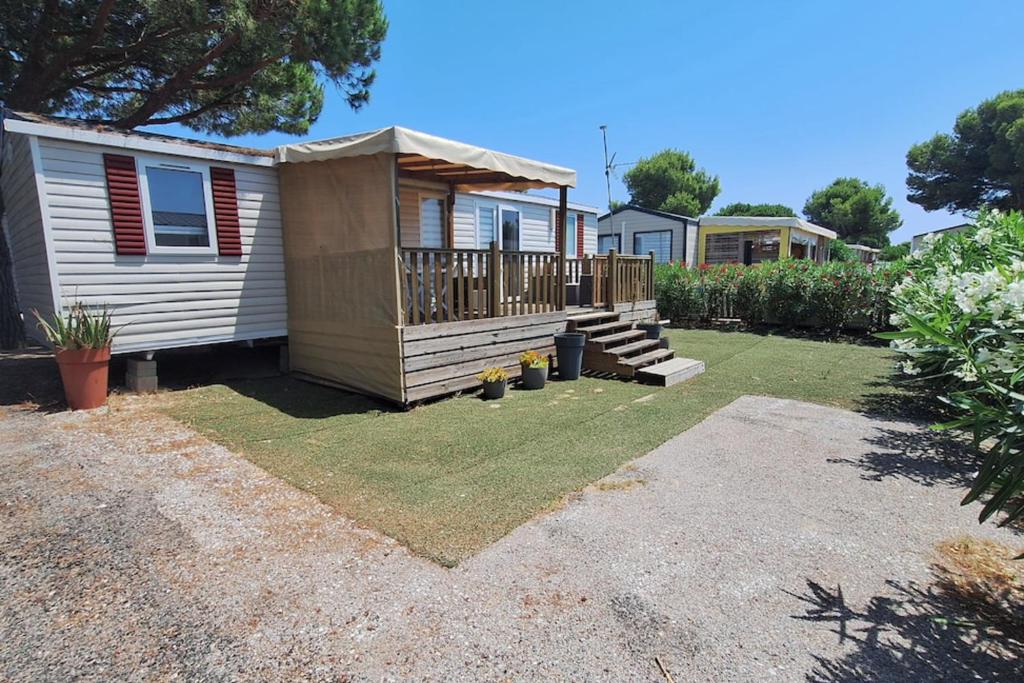 une arrière-cour avec une petite maison avec une terrasse dans l'établissement Comfortable 2-bedroom mobile home, à Canet