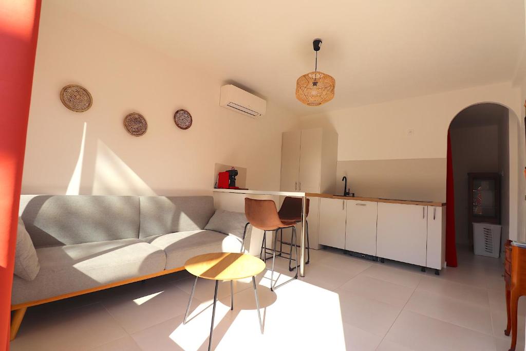 a living room with a couch and a table at T2 Ajaccio- Neuf tout confort- Wifi et Parking gratuit- 5min du centre ville- Proche aéroport et port- secteur Finosello in Ajaccio