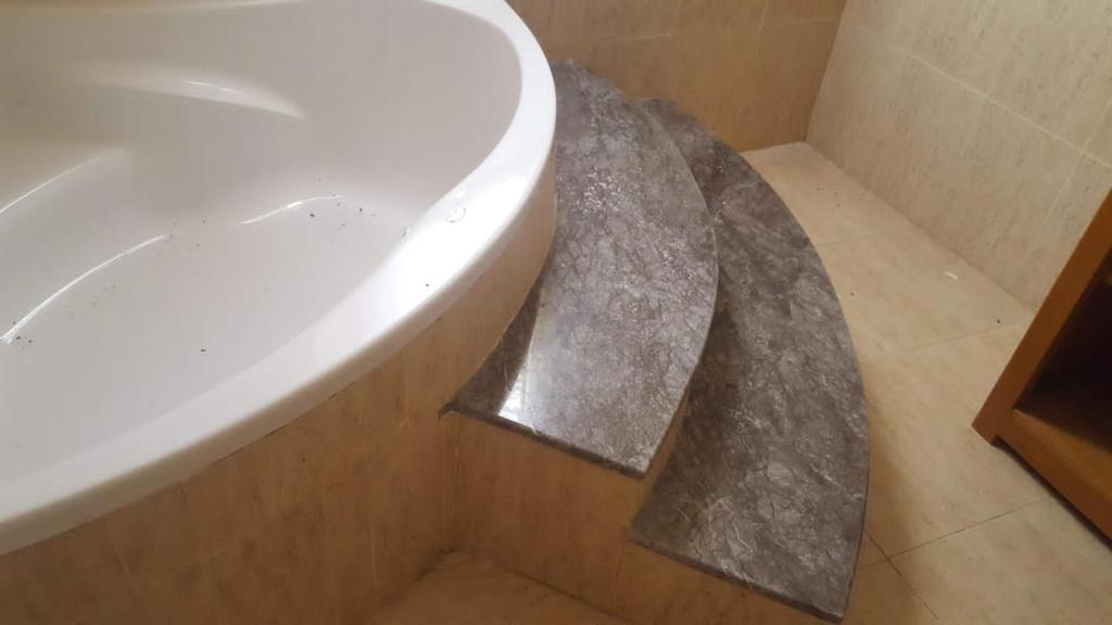 une salle de bain avec une baignoire blanche avec un comptoir en marbre dans l'établissement Villa elhouda, à Essaouira