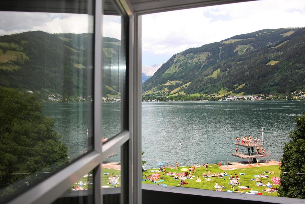 a view from a window of a lake with a beach at Seehotel Sissi am Zeller See in Zell am See