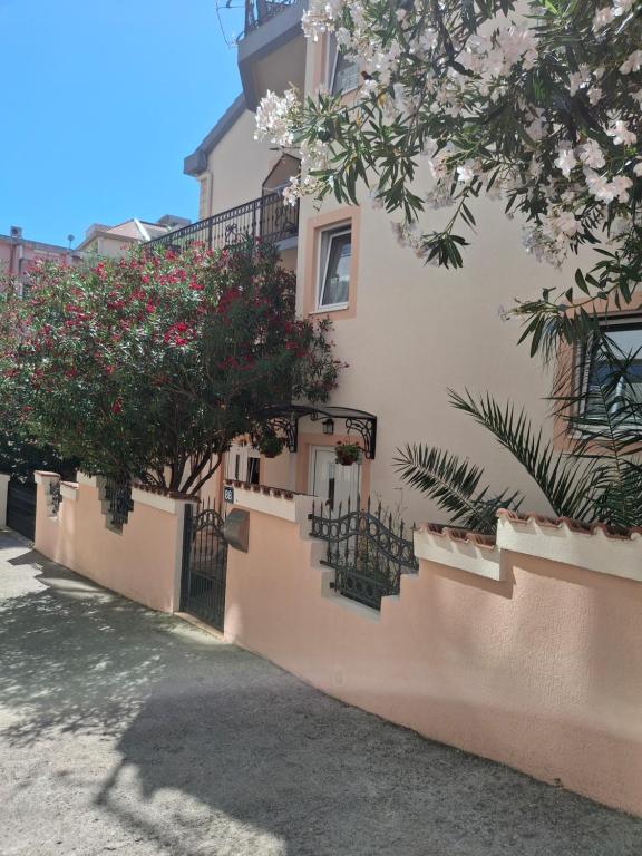 a white building with stairs and flowers on it at Apartmani Aleks in Budva