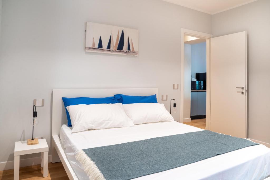 a bedroom with a large white bed with blue accents at GuestHost - Casa Innocenza in Ravenna
