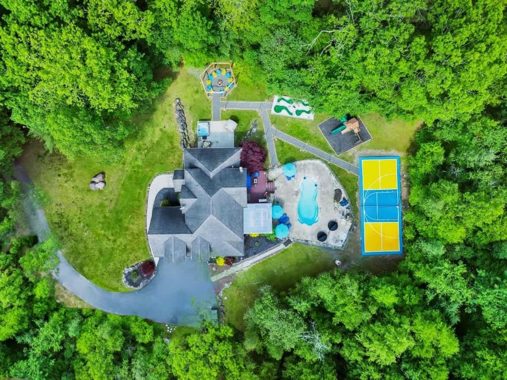 an aerial view of a mansion in the woods at Sleeps 14 Pool Hot Tub Sauna Pickleball Arcade in Stroudsburg