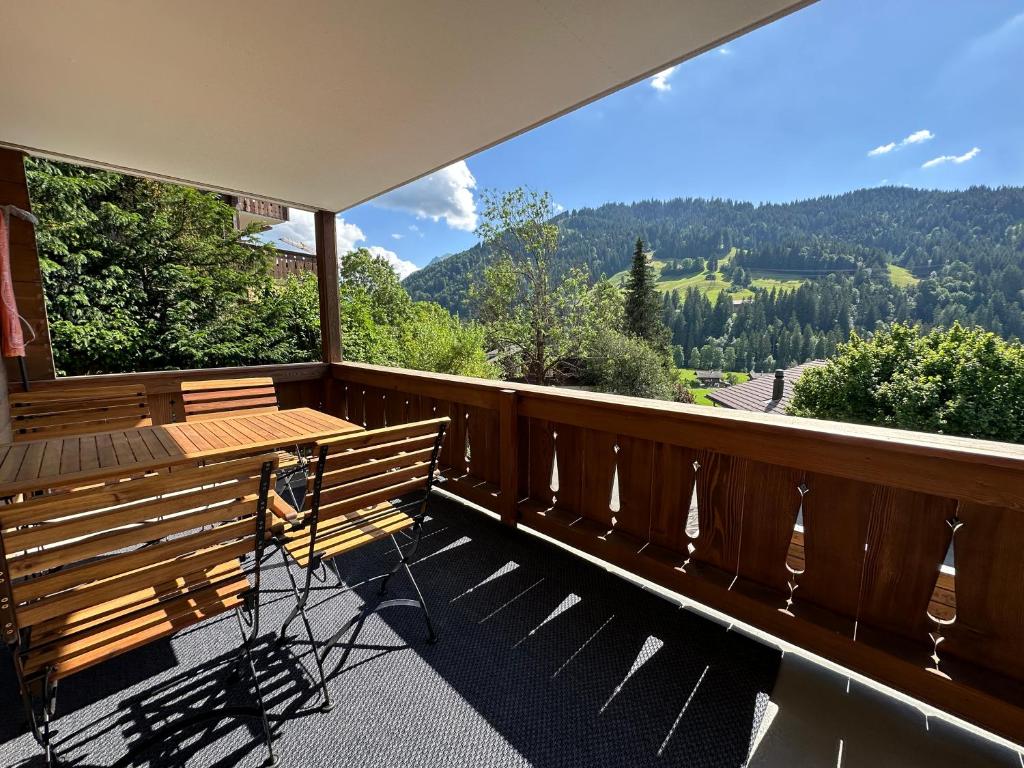 格施塔德Gstaad Central and View的带木凳和桌子的阳台