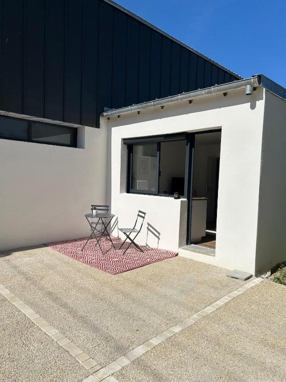 two chairs and a table in front of a building at Studio calme avec terrasse proche centre-ville in Niort