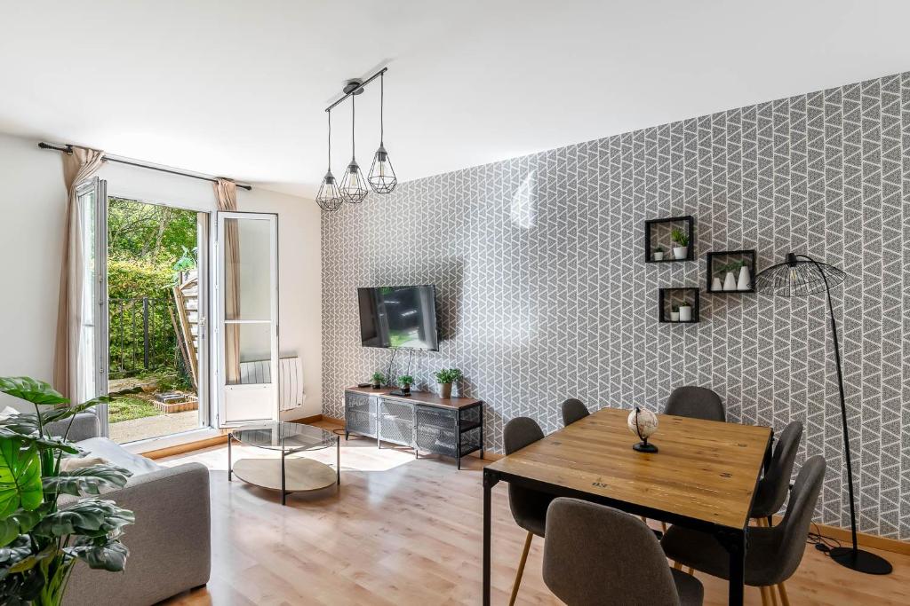 un salon avec une table et une télévision dans l'établissement 2 Bedroom apartment Galmy Val d'Europe, à Chessy