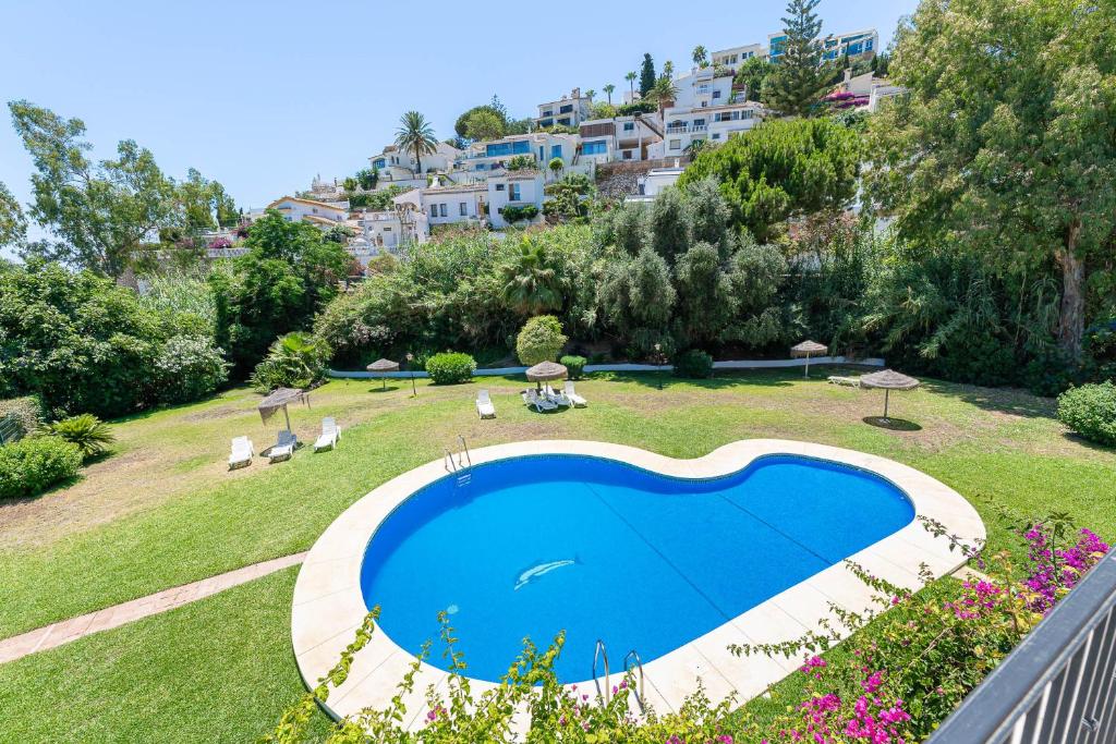 ein großer blauer Pool in einem Hof mit Gebäuden in der Unterkunft Townhouse Cortijos de La Hidalga in Torremuelle
