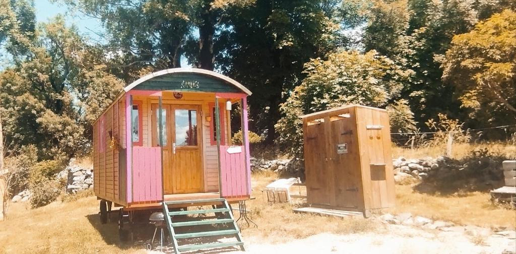 an out house and a small shed in a field at La Roulotte romantique des volcans in Saint-Saturnin