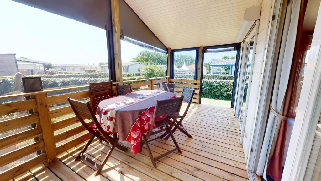une terrasse avec une table et des chaises. dans l'établissement La Paranthese Marine, à Brem-sur-Mer