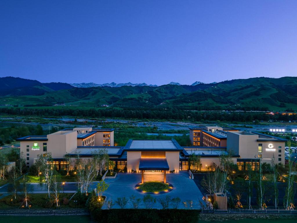a hotel at night with mountains in the background at Holiday Inn Express Nalati By IHG in Narat