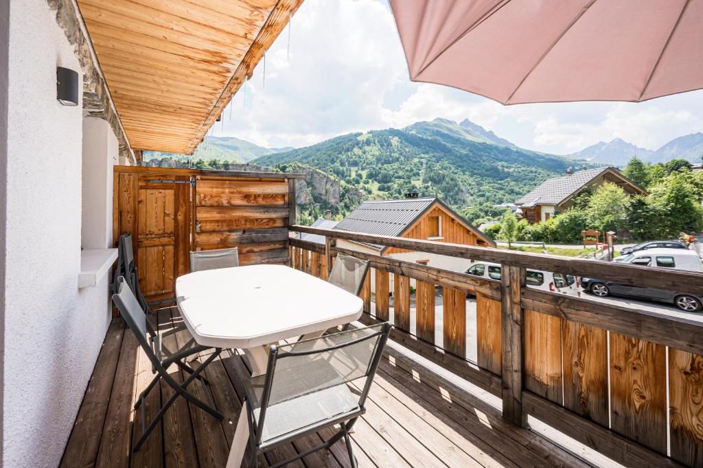 - un balcon avec une chaise et un parasol dans l'établissement Chalet - Le crey rond, à Valloire
