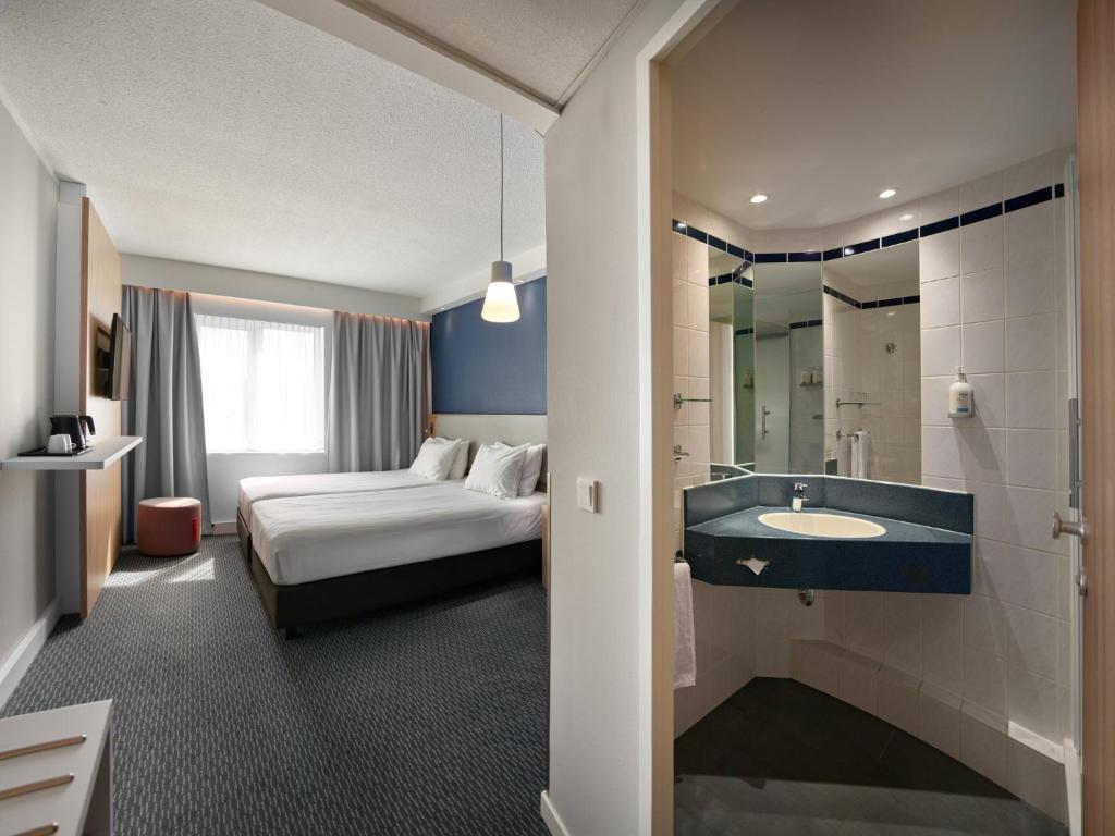 una camera d'albergo con un letto e un lavandino di Holiday Inn Express Antwerpen City North by IHG ad Anversa