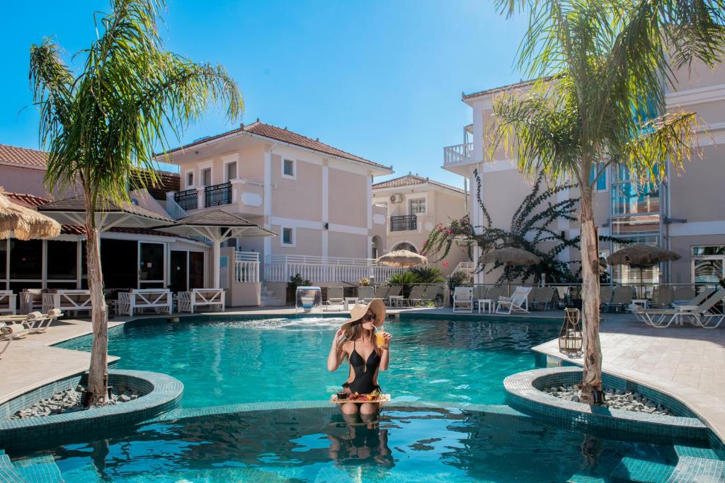 a woman is standing in the water in a swimming pool at Tzante Hotel Zakynthos, Adults Only in Laganas