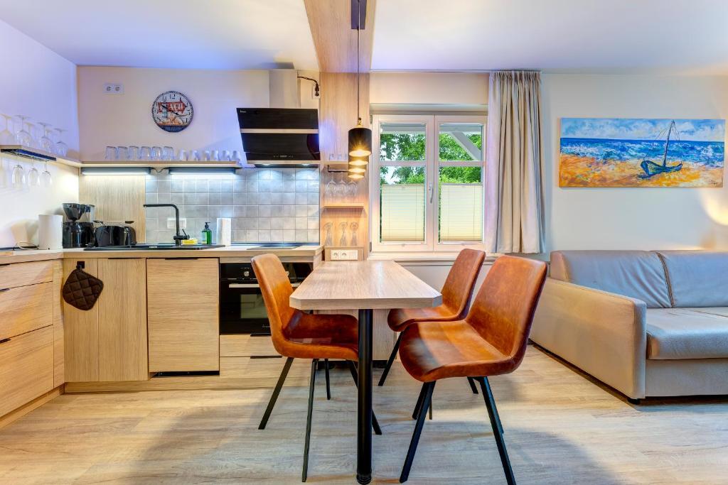 a kitchen and living room with a table and chairs at Dünenhäuser Ückeritz UnserUsedomDe FeWo ca40qm direkt am Strand 1I1 in Ueckeritz